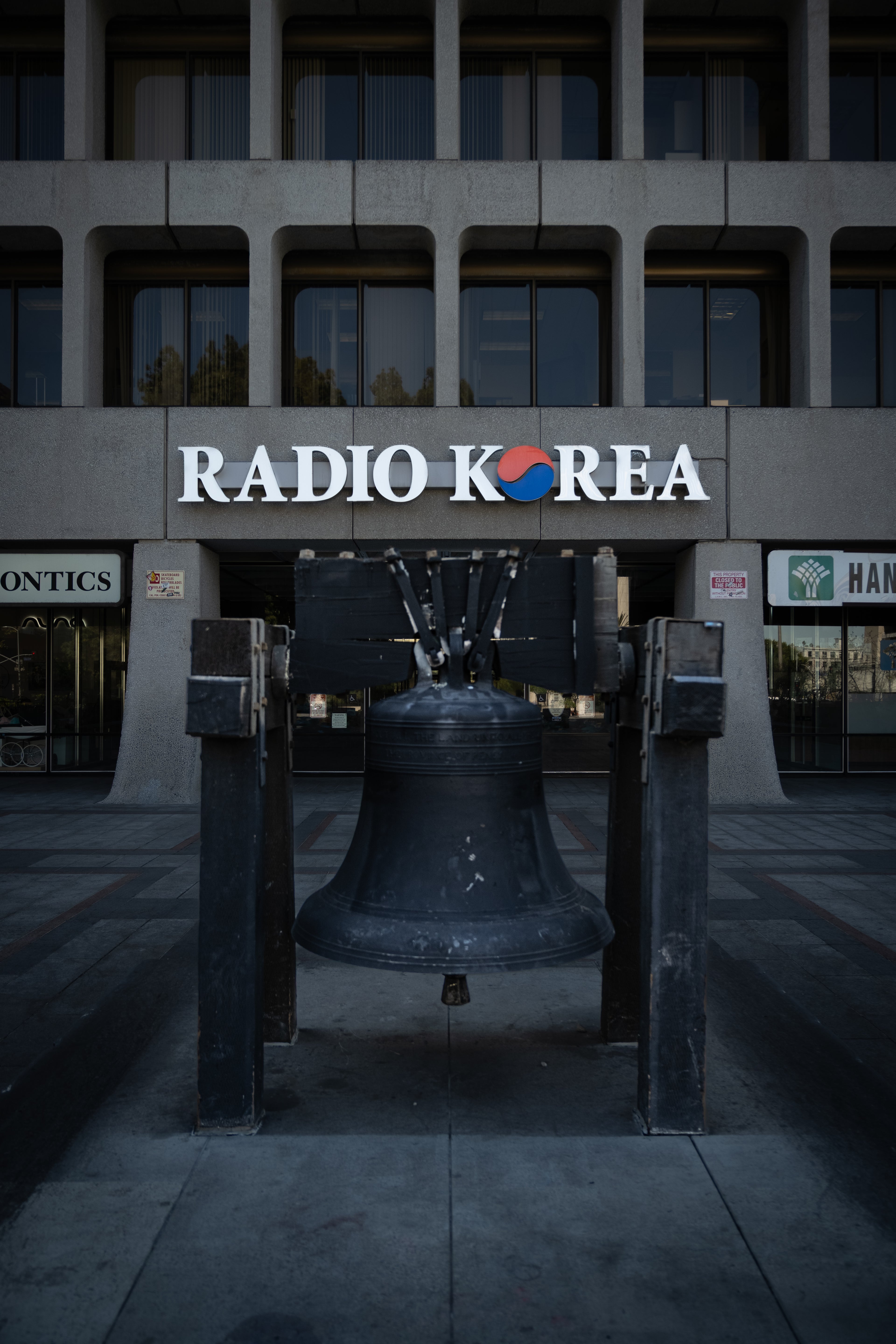 Image of the front of the Radio Korea building featuring the Radio Korea sign in front of a replica of the Liberty Bell.